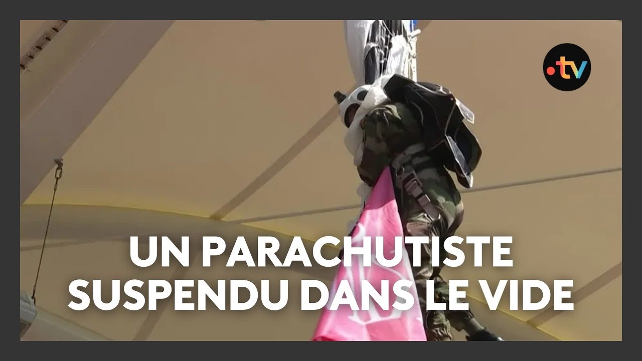 Un parachutiste suspendu dans le vide accroché au toit du Stadium