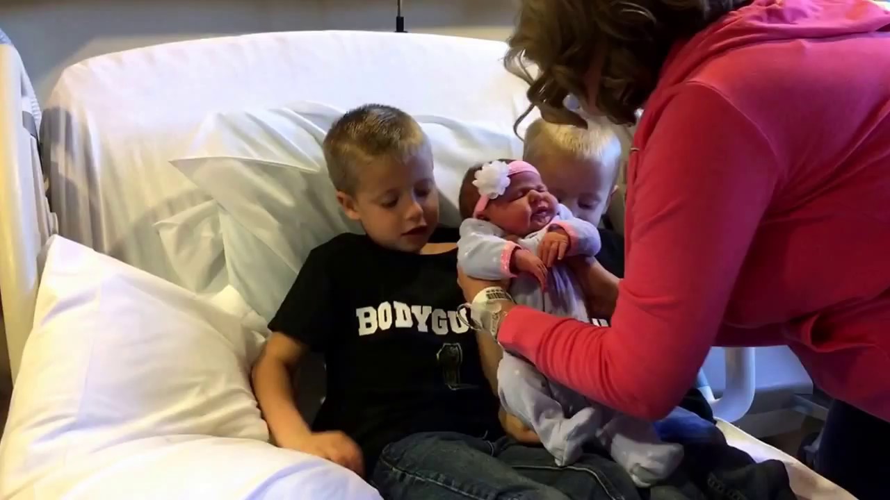 Holding their baby sister
