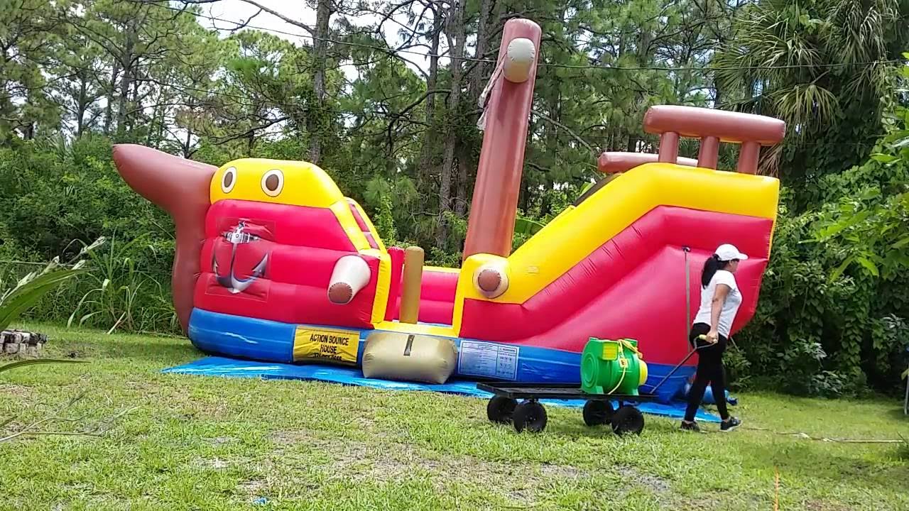 Julie roll up the pirate ship bounce house using the deflator