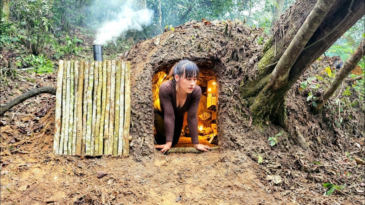 Building a shelter from fallen tree stumps, a fire burning underground - solo survival