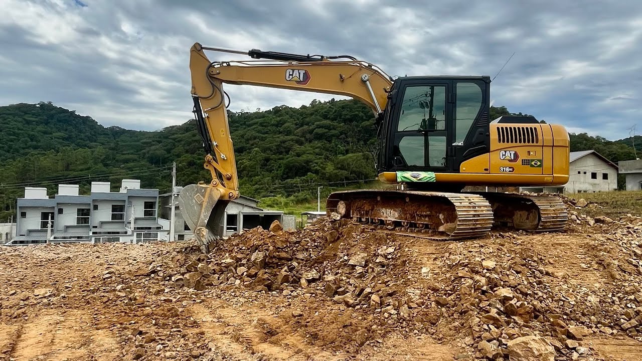 Escavadeira caterpillar fazendo rebaixe e nivelamento do lote 