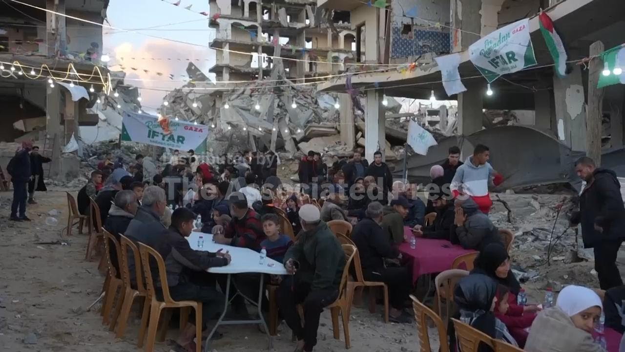 Palestinians gather for communal Iftar in Gaza City amid rubble and hollowed out buildings