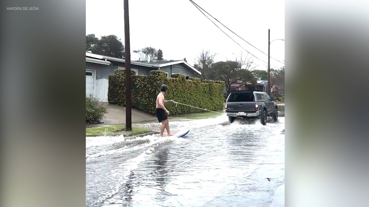 Man seen surfing through Long Beach streets during heavy flooding
