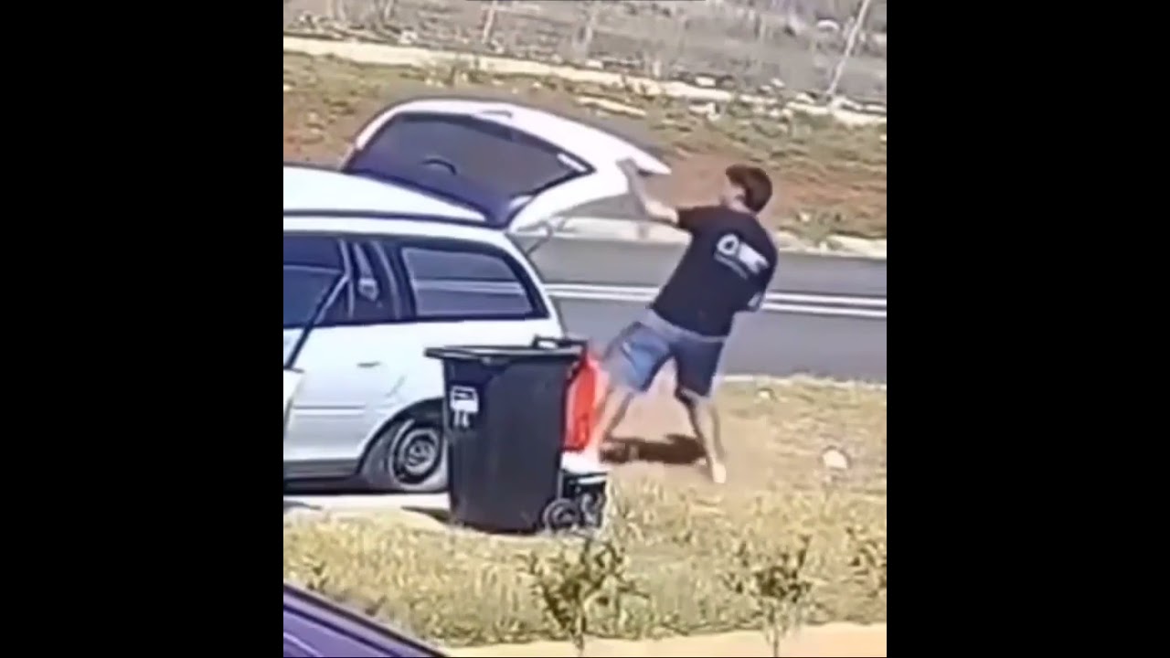 guy hitting his head on an open car trunk