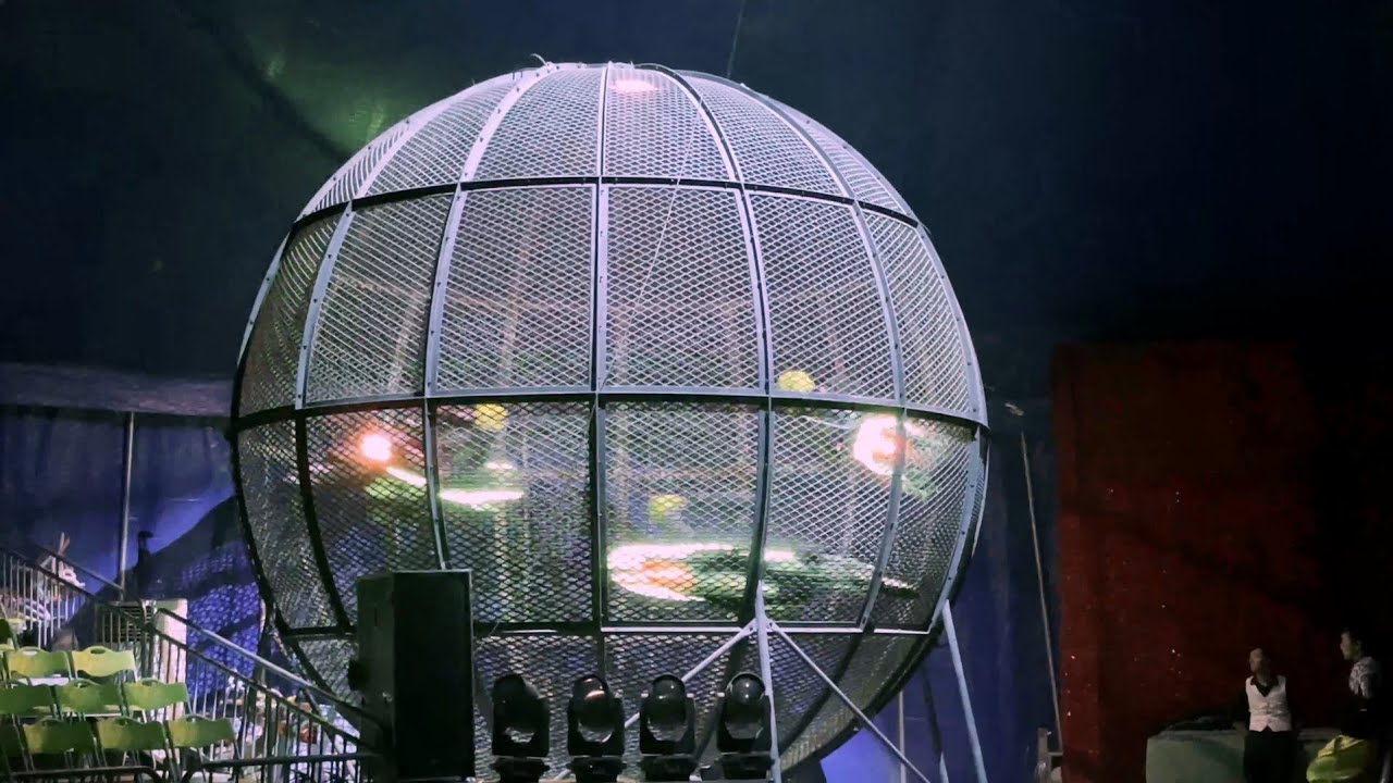 Asphalt Acrobatics（Three motorcycles are spinning inside the spherical cage.）