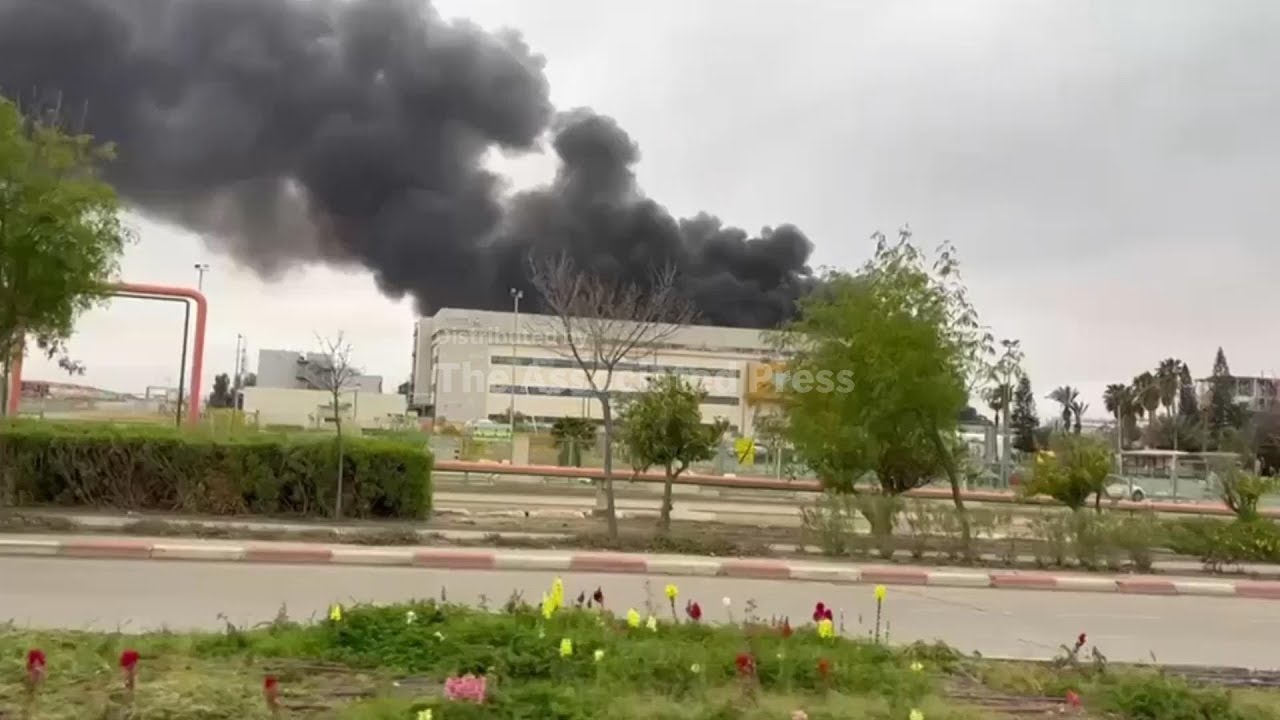 Black smoke cloud rises from fire at factory hit by missile fragment in southern Israel