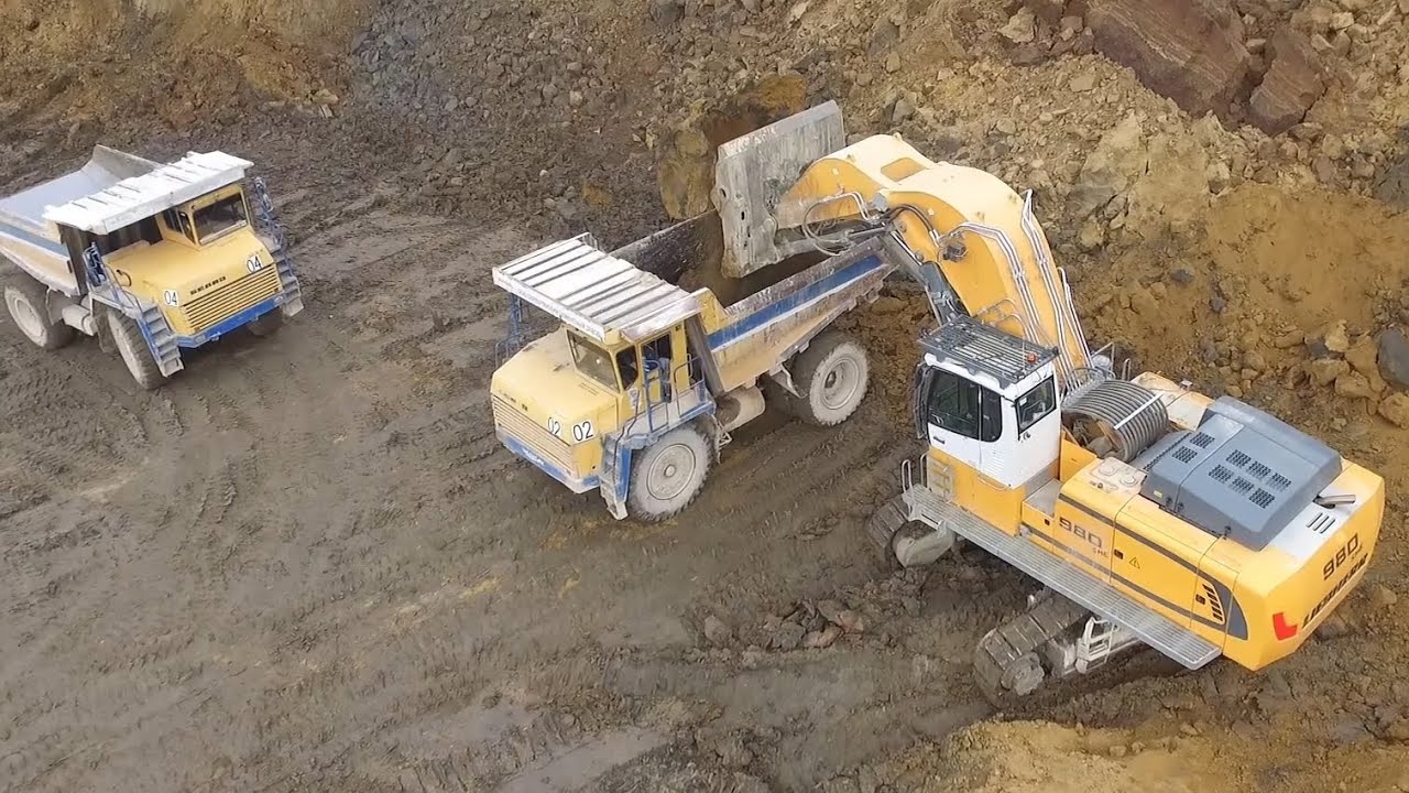 Экскаватор с прямой лопатой Liebherr R980 SME Front Shovel грузит Белазы в карьере - Drone video