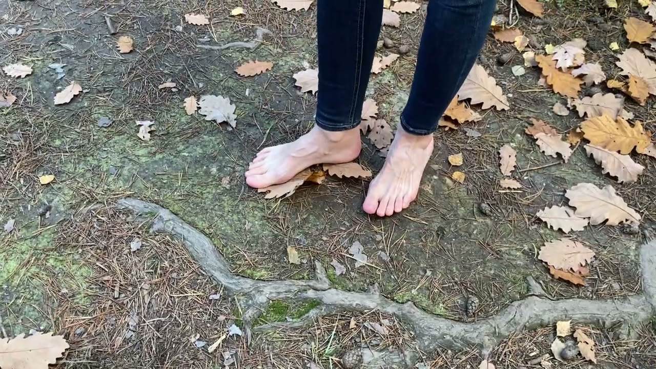 barefoot girl walking on leaves and ground in an autumn forest