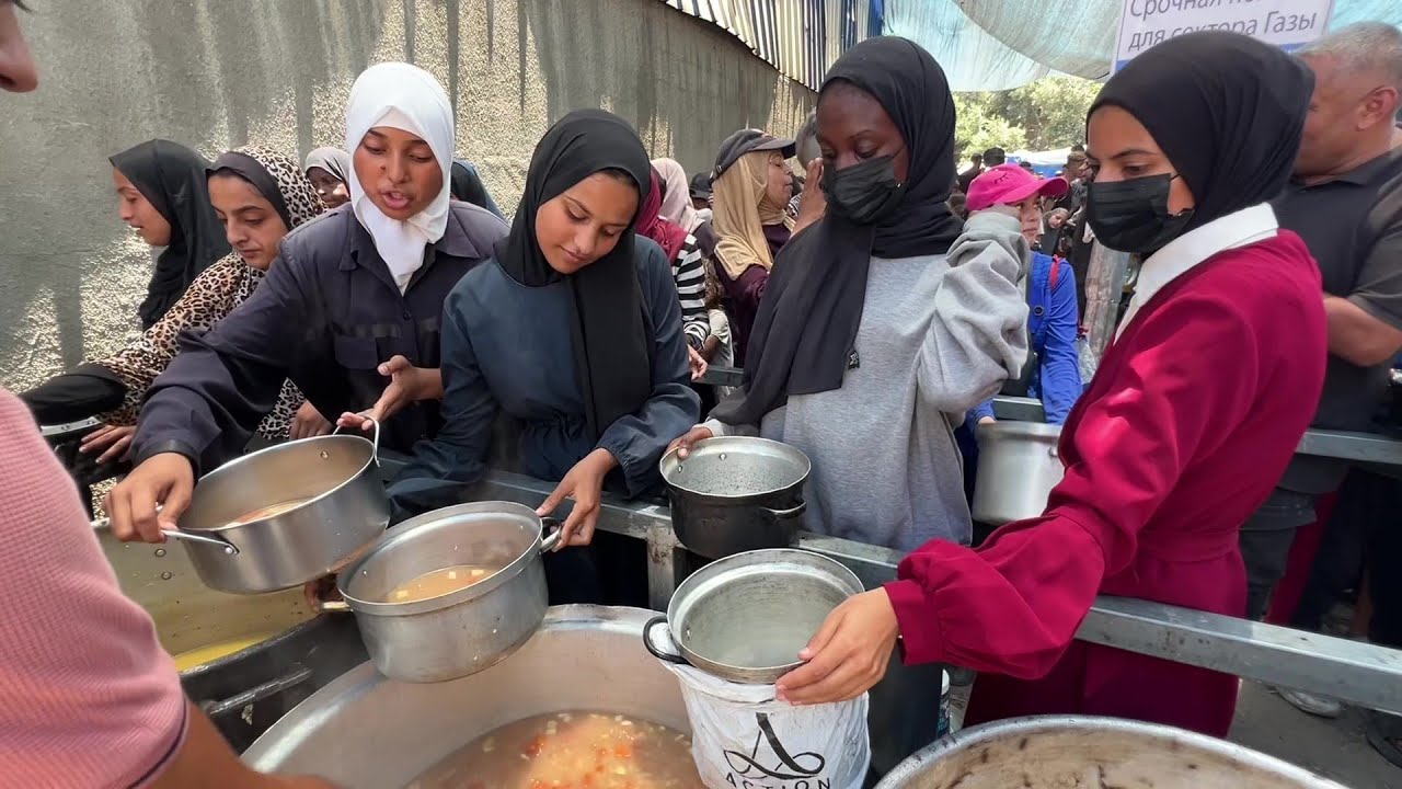 نازحون يتجمعون للحصول على القليل من الطعام من تكية خيرية في مخيم النصيرات وسط قطاع غزة