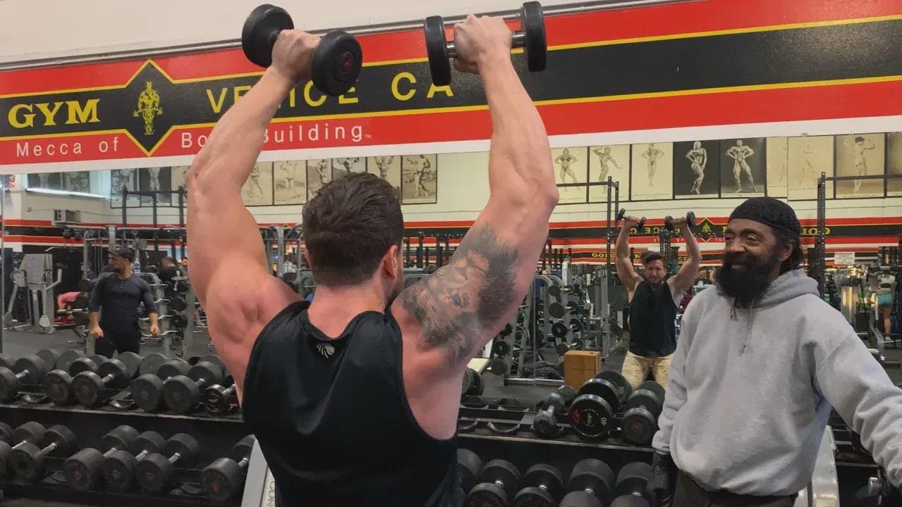 Entraînement épaules avec haltères avec le parrain du bodybuilding