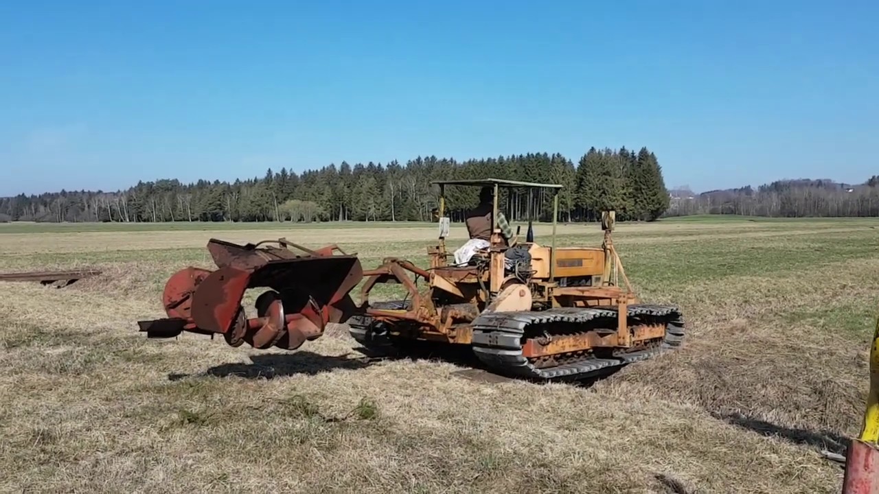 Steyr 50 Plus Raupentraktor mit Grabenfräse im Einsatz.  Trench cutting machine