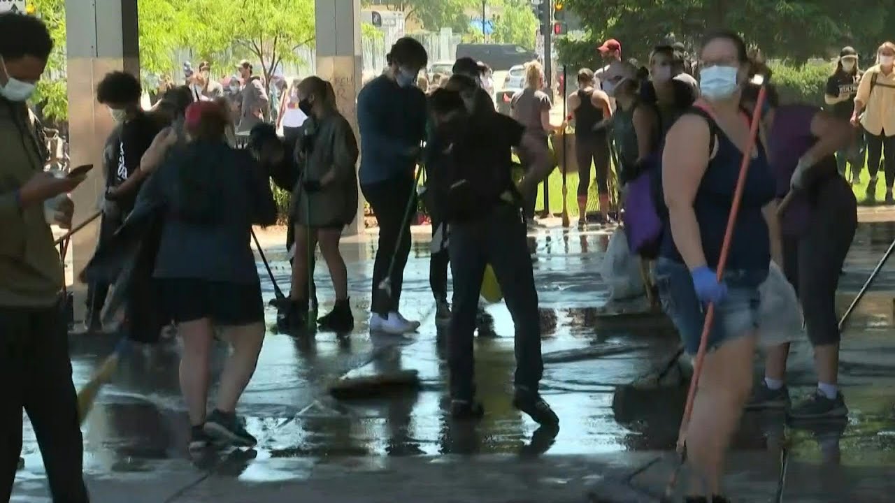 People clean up bank and businesses in Minneapolis after night of protests | AFP