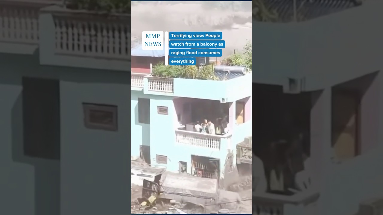 Unbelievable Flood Waters Devastate Town. People stranded watch from a balcony