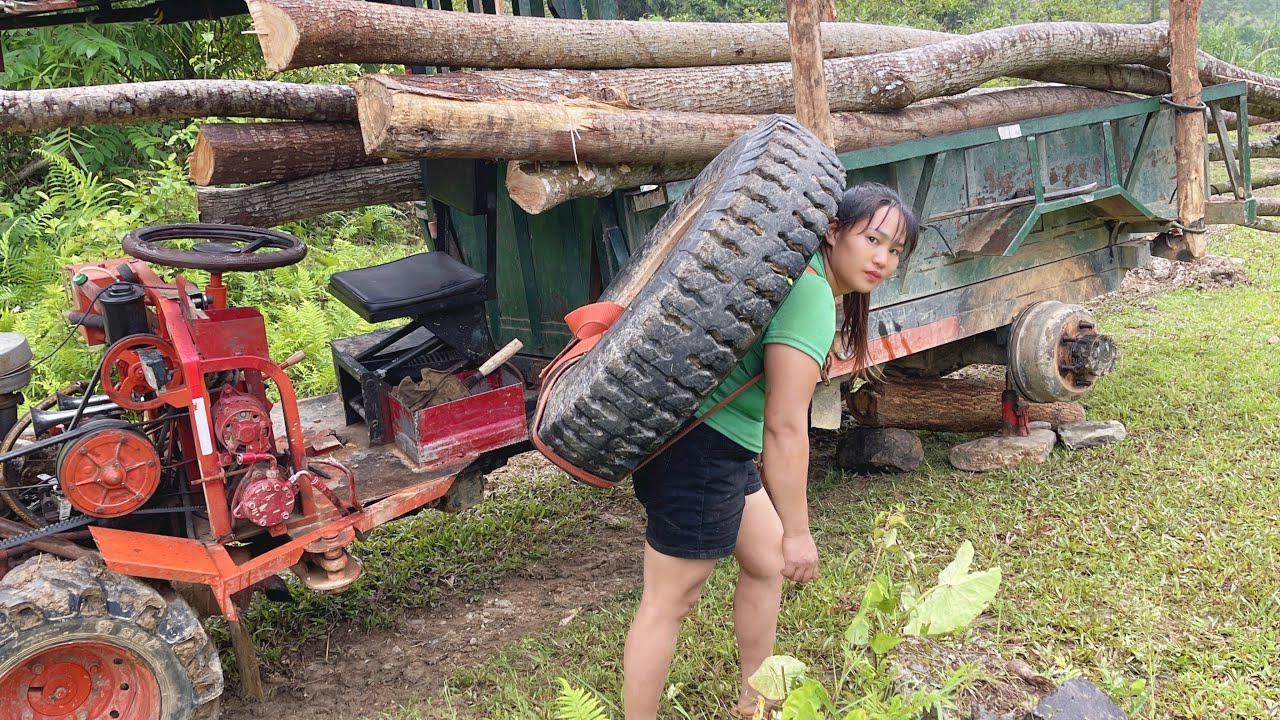The girl's farm vehicle had a flat tire while transporting timber.