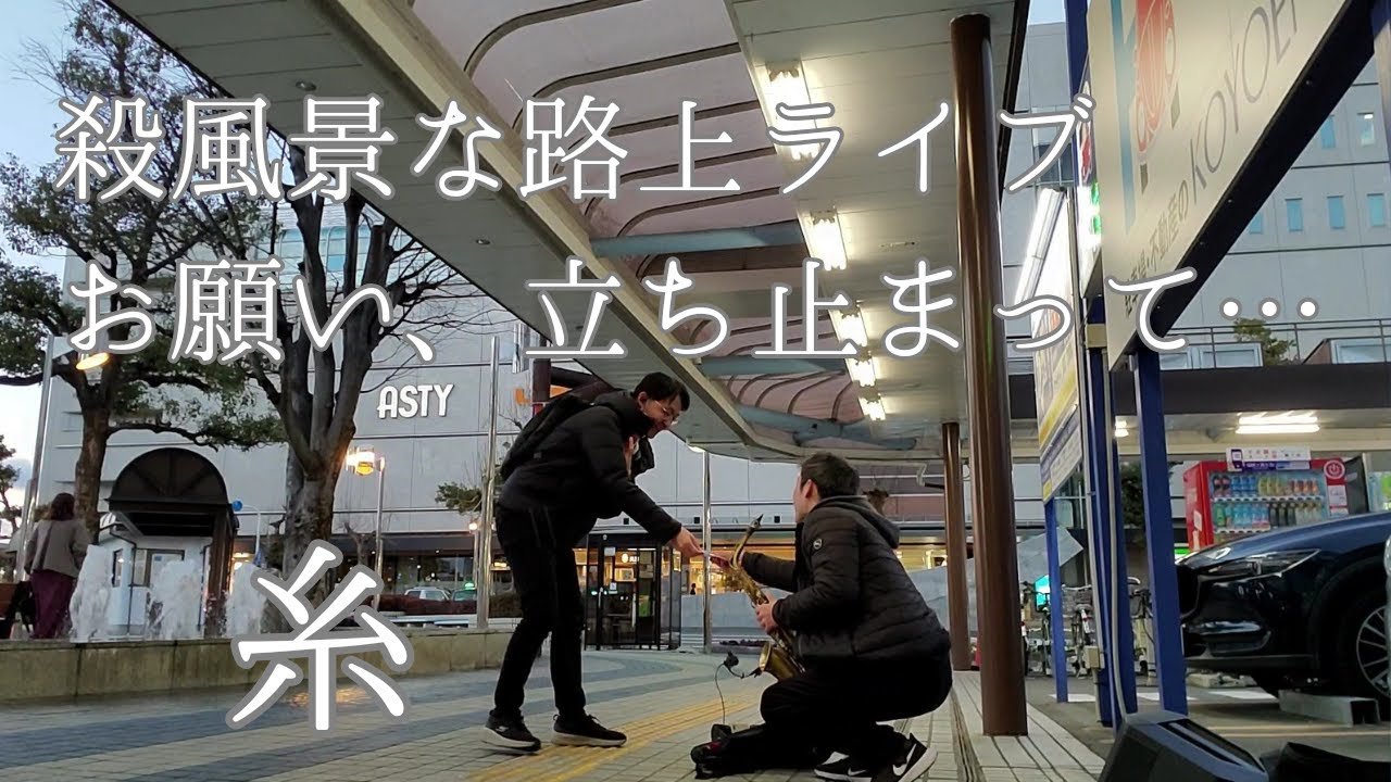 サックス奏者が糸を「路上ライブ」。　立ち止まってー…。