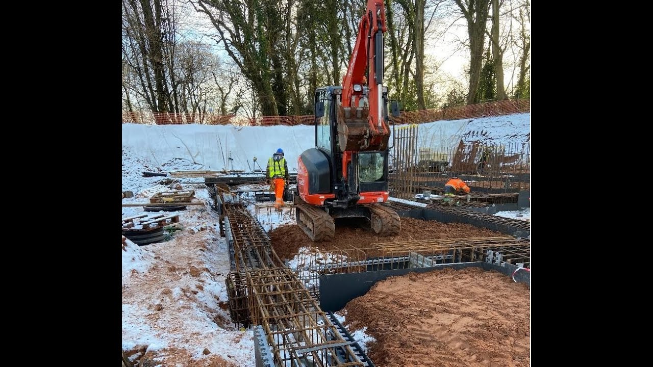 Helping out the steel fixer foreman working on foundation ground beams for basement construction