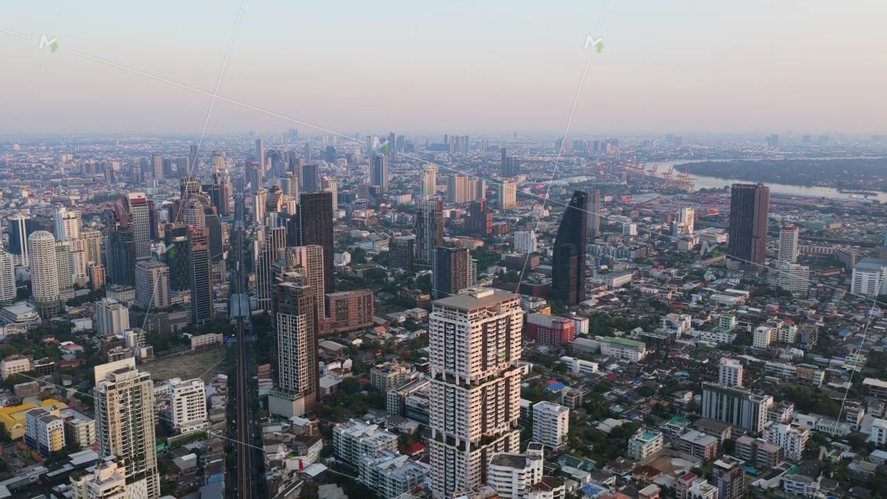 Tripod aerial view of Bangkok's sprawling metropolis during a hazy sunrise. Iconic skyline shows