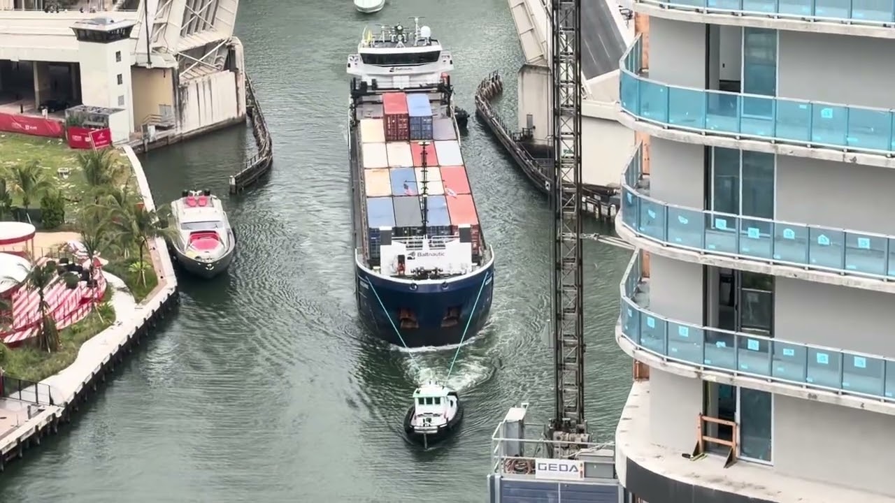 Tugboat Bringing Cargo Ship Into The Miami River 