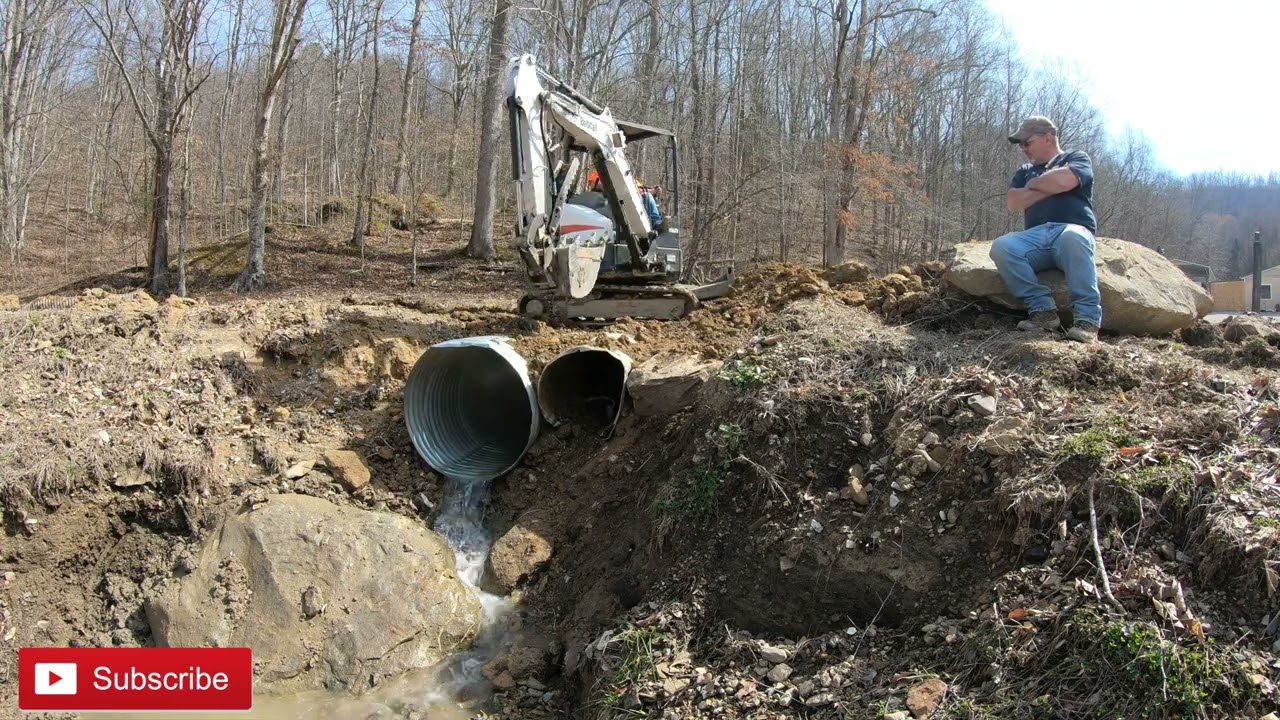 Replacing a rusted culvert in a driveway with a e26 bobcat excavator.