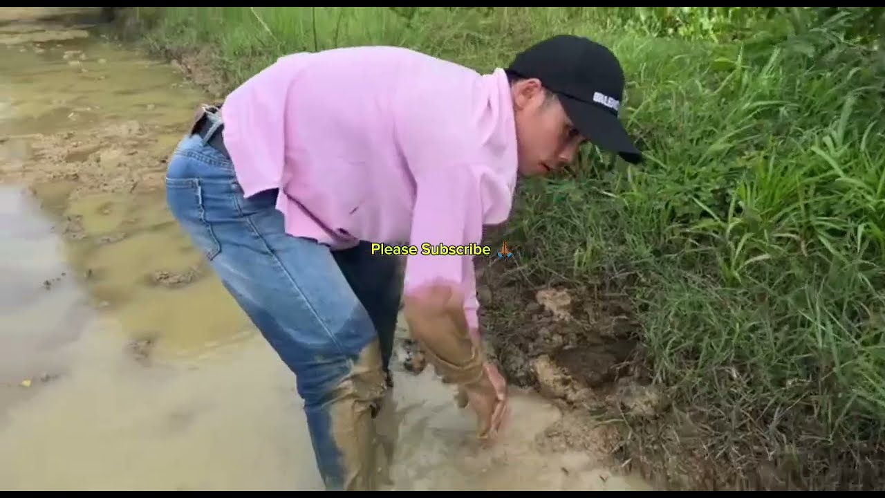 Exploring the muddy banks in search of fish hiding in small water holes  a traditional and skillful