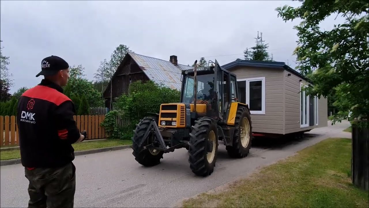 Transport domku mobilnego DMK ciągnikiem rolniczym na miejsce docelowe- domki mobilne producent DMK