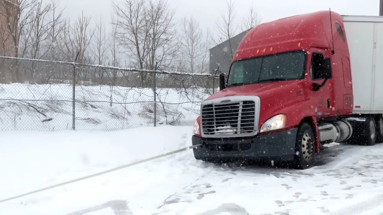 2018 Jeep JLU Rubicon on ice pulling a Semi out of a ditch