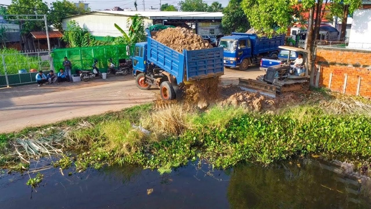 Delete the pond using soil pushing by skill dozer with 5ton trucks uploading soil