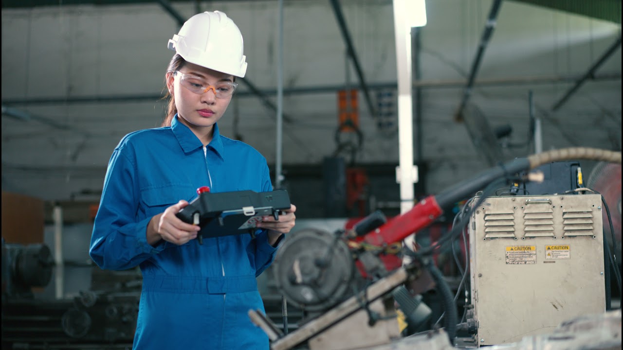 Engineering woman, she is testing the robot arm.