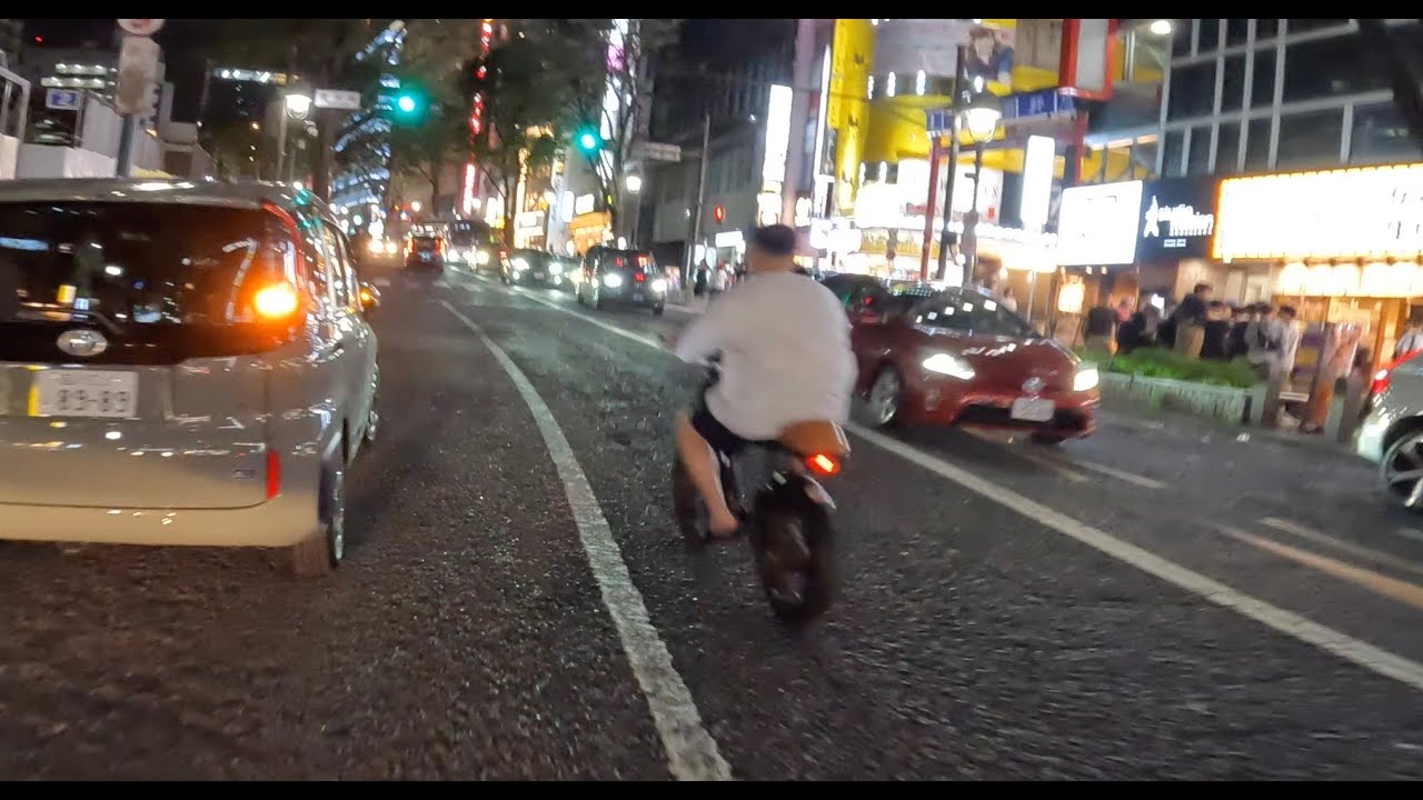 東京・渋谷の道玄坂を爆走してする違法違法電動バイク・モペットに遭遇。乗るのは中国人風の男。ナンバー無し、ヘルメット無し、耳にはイヤホンの違反オンパレード。なぜ警察は違法モペットを放置するのか！？