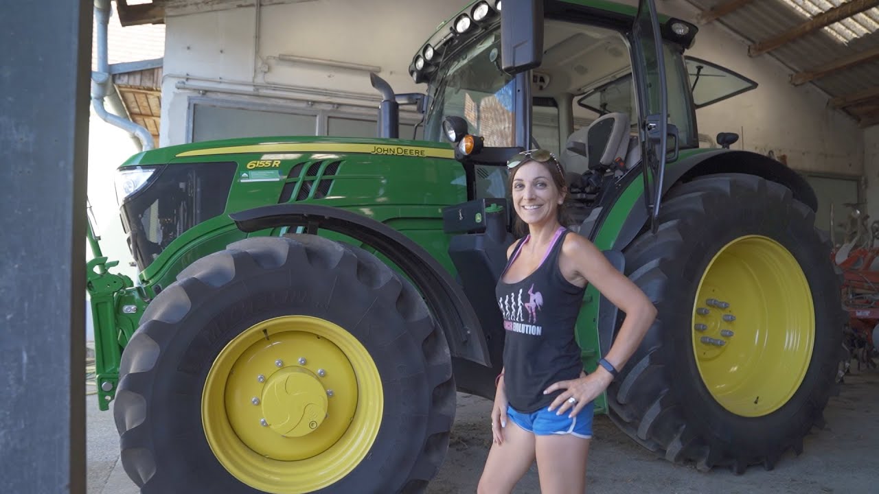 Farmer girl is changing to a new John Deere 6155 R tractor