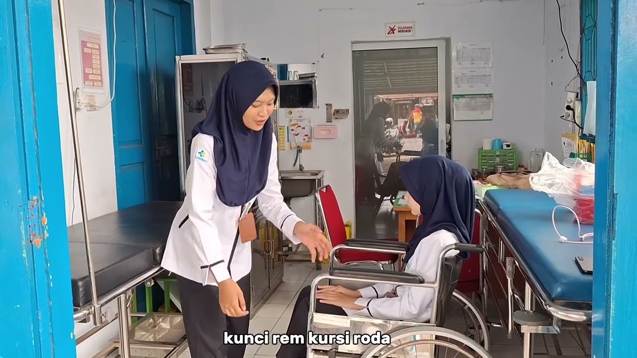 Mengangkat pasien dari tempat tidur ke kursi roda dengan prinsip body aligment 