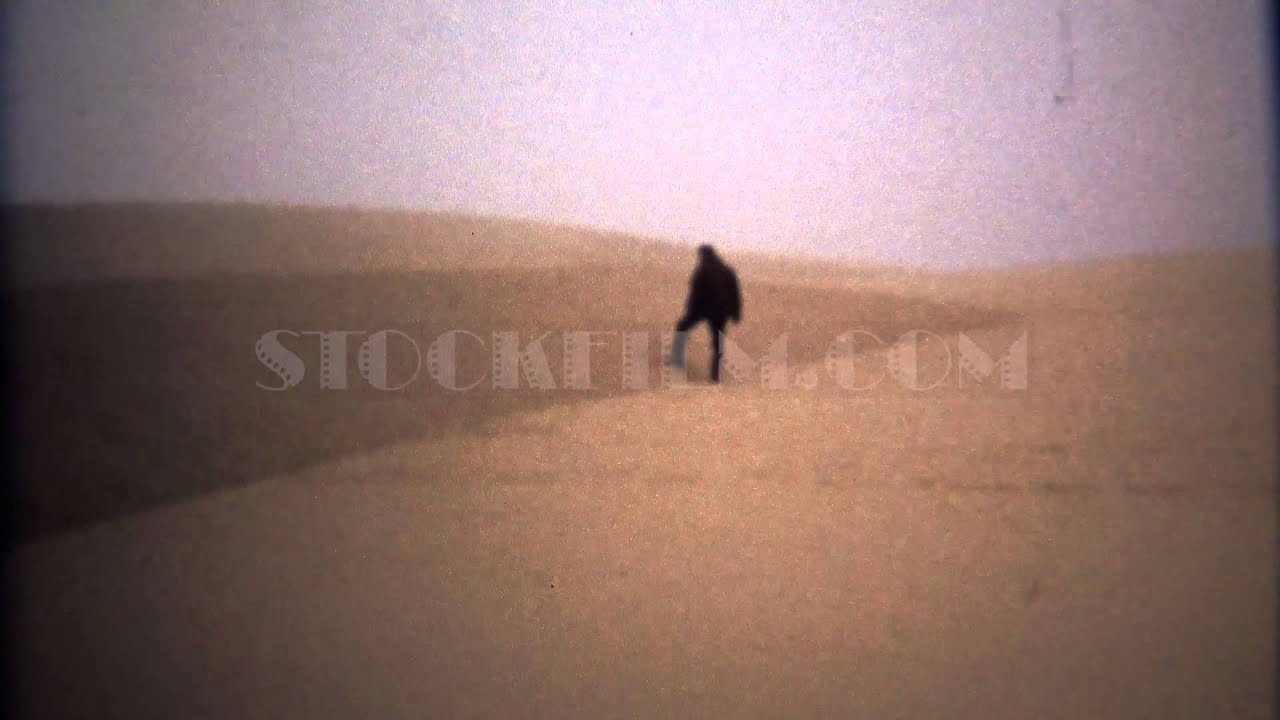 1971: Man walking in blonde yellow sand desert alien landscape.  ASTORIA, OREGON