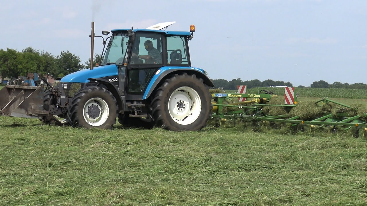 New Holland TL100 met Krone KW 13.02/12T aan het gras schudden