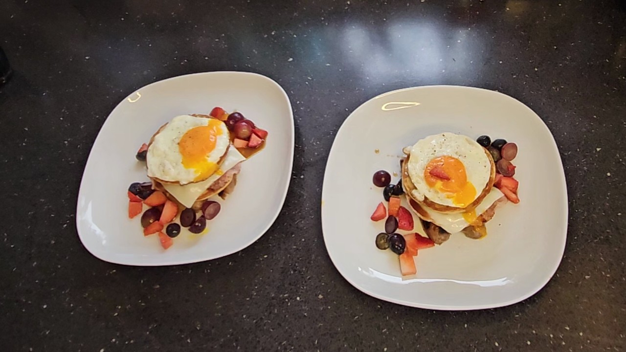 Buttermilk pancake breakfast stack, with sausage, bacon, egg and fruits.