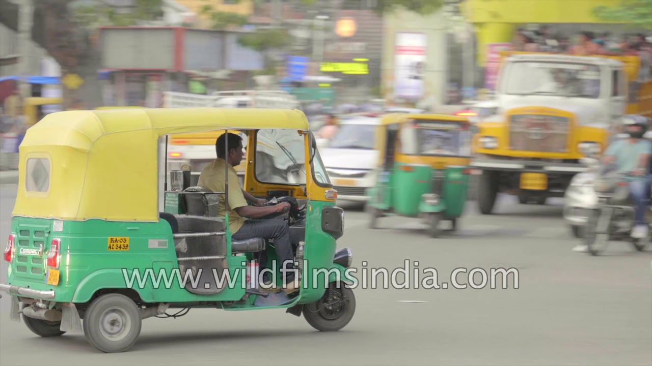 Green-yellow auto rickshaw tuk-tuks on Bengaluru's roads