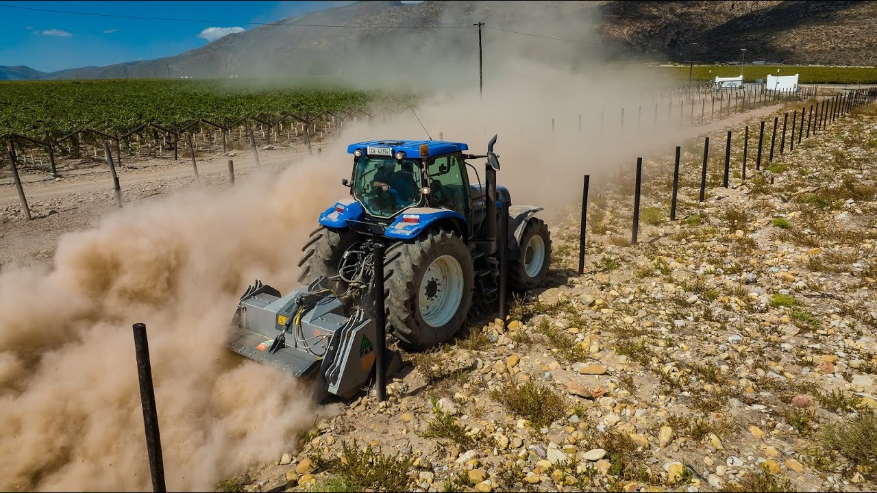 FAE STC200DT PTO Stone Crusher machine behind New Holland T7040 tractor crushing rocks in vineyards