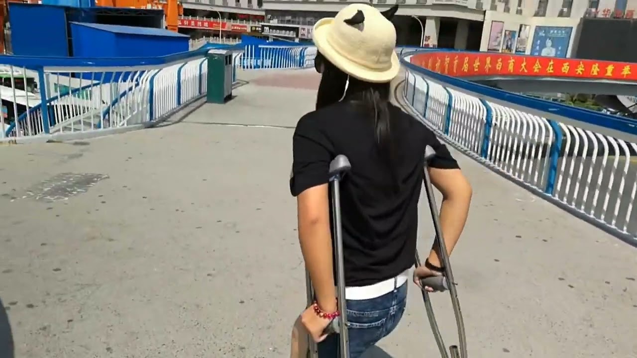 The beautiful woman has an amputated leg and is climbing the stairs on one leg and on crutches