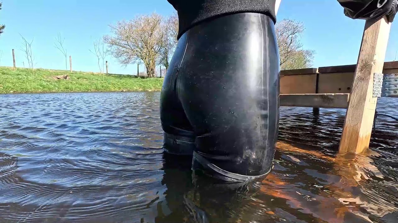 Video 108 - Back to Black - Taster (latex rubber catsuit, Acquo thigh high boots, swim, pond, mud)