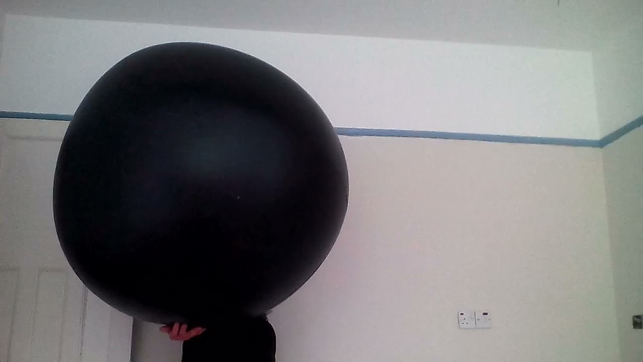 Mouth inflating a large out of shape, black beach ball (Edited video)