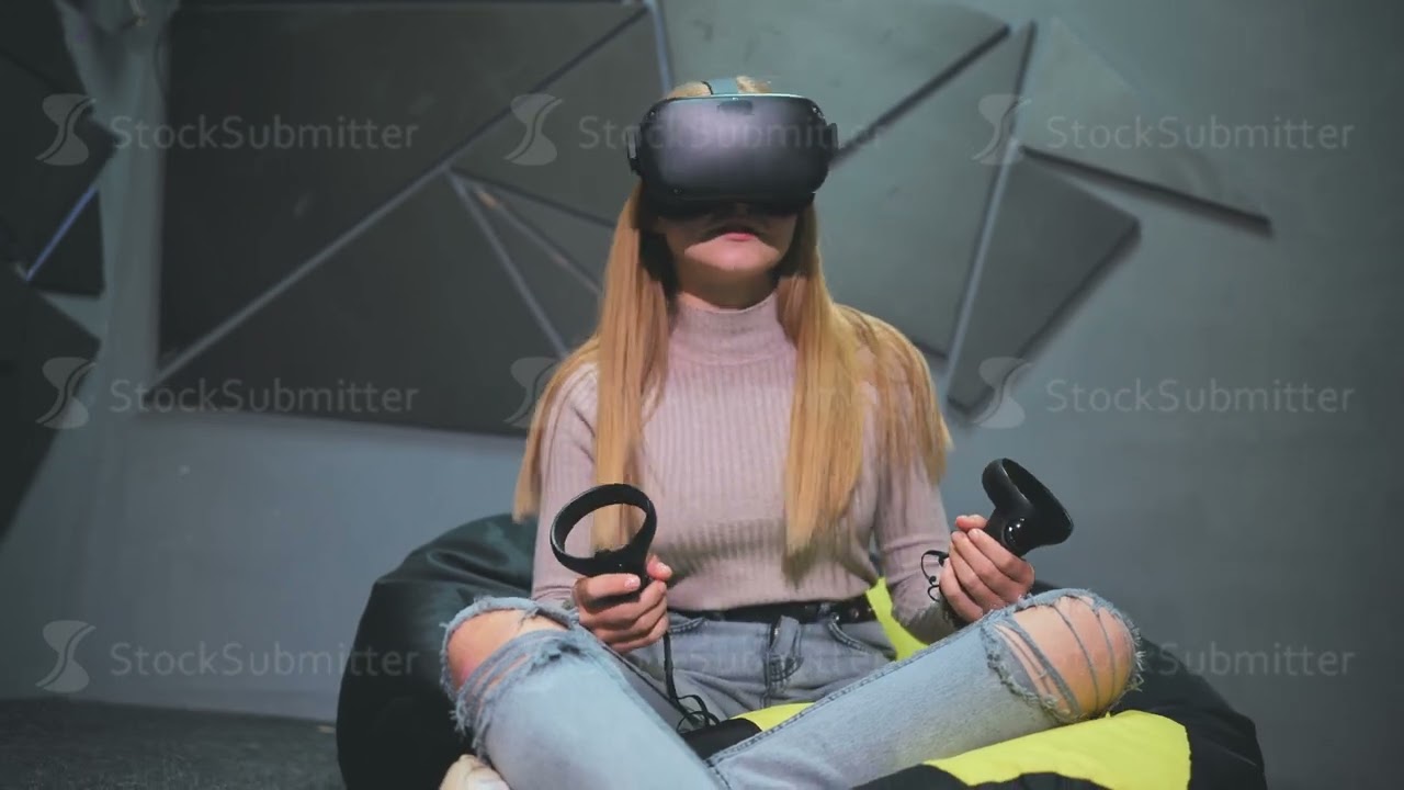 A teenage girl sits in a club with virtual glasses and plays.