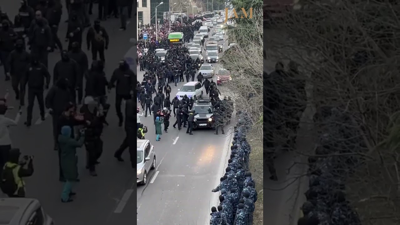 Riot police in Tbilisi kick a car after the driver honked in solidarity with protesters