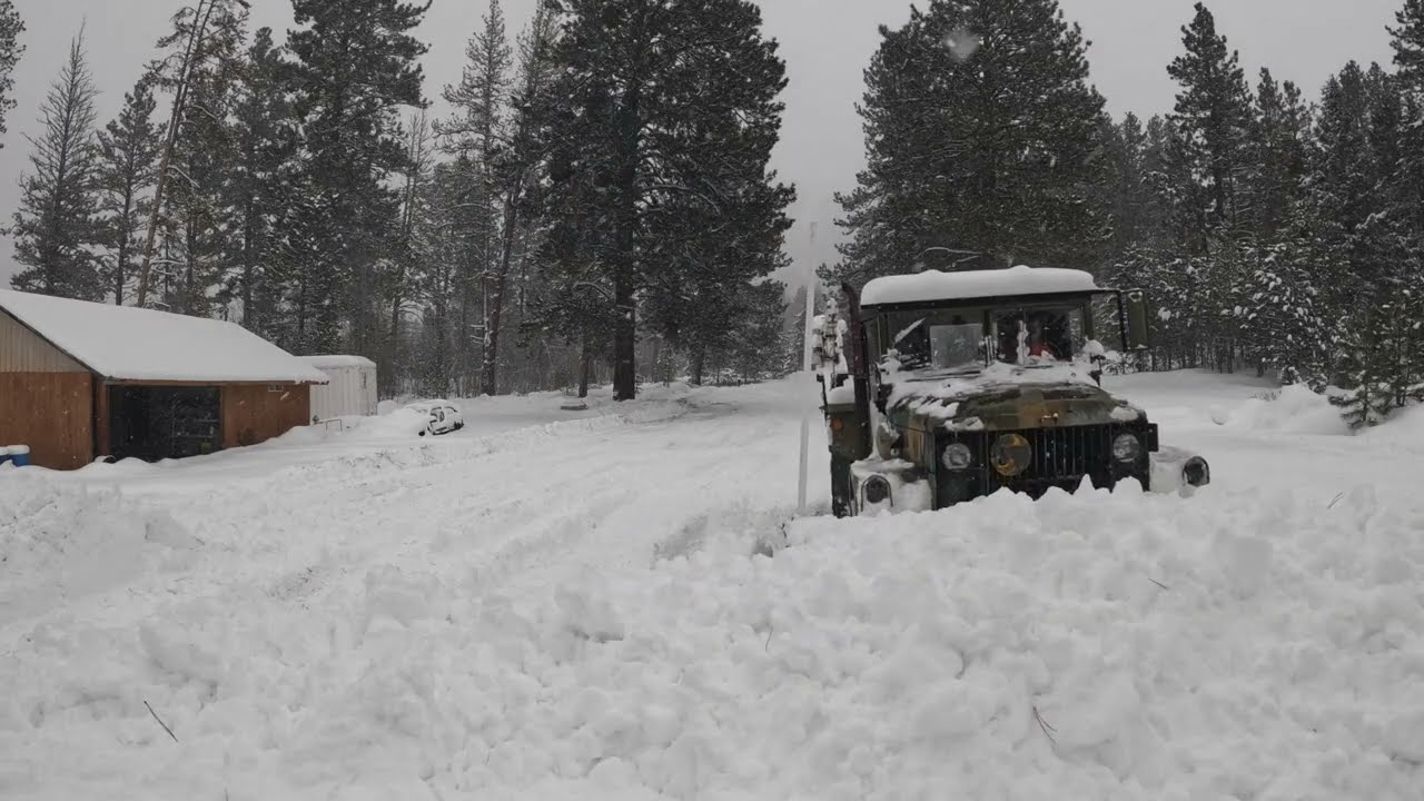 Old deuce and a half army truck plowing snow.
