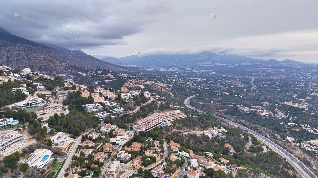 Luxury coastal view. Picturesque aerial image of coastal property featuring pools and mountain