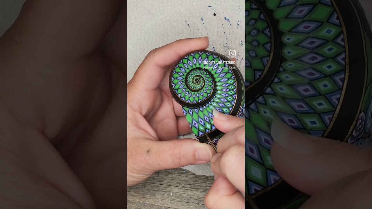 Painting the spiral on a snail shell with snakes and roses 