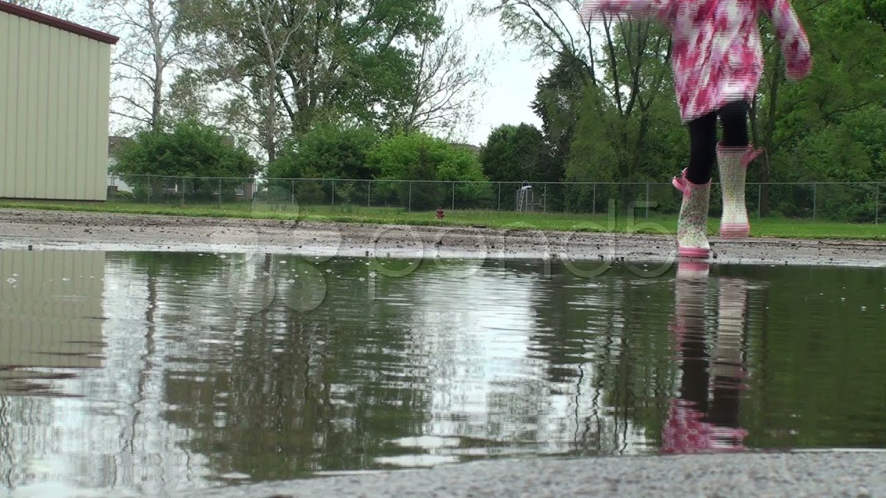 Puddle Jumping - Little Girl Splashing Camera. Stock Footage