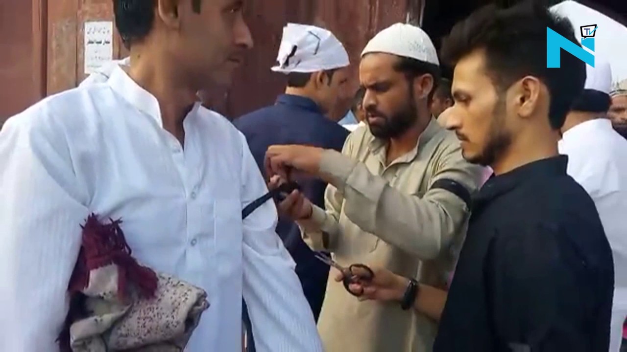 People tie black bands in protest against lynching of Muslims