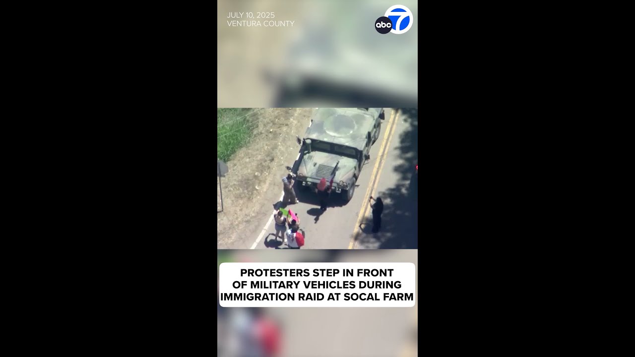 Protesters step in front of military vehicles during immigration raid at SoCal farm