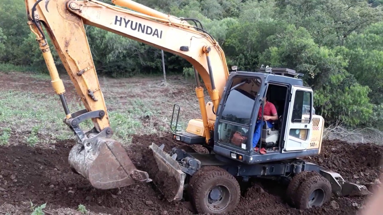 Escavadeira hidráulica com pneus Hyundai 140 em local difícil