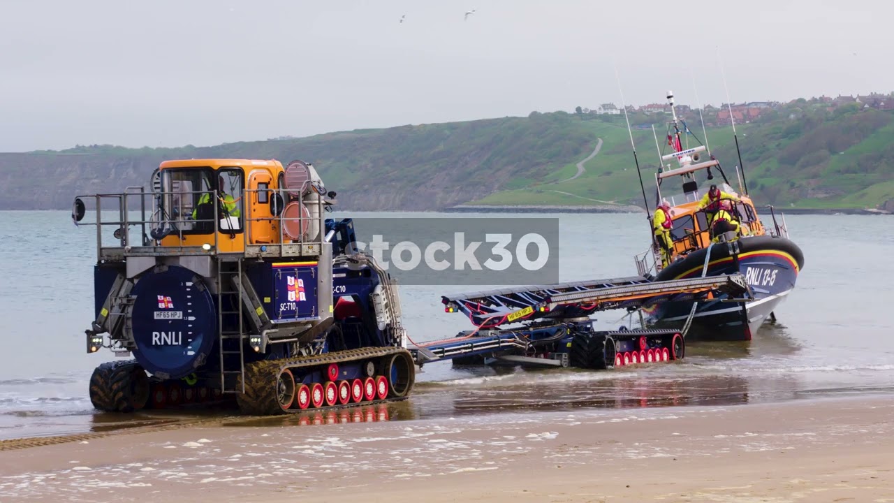 Recovery Vehicle Preparing To Retrieve RNLI Lifeboat, Scarborough Beach, UK