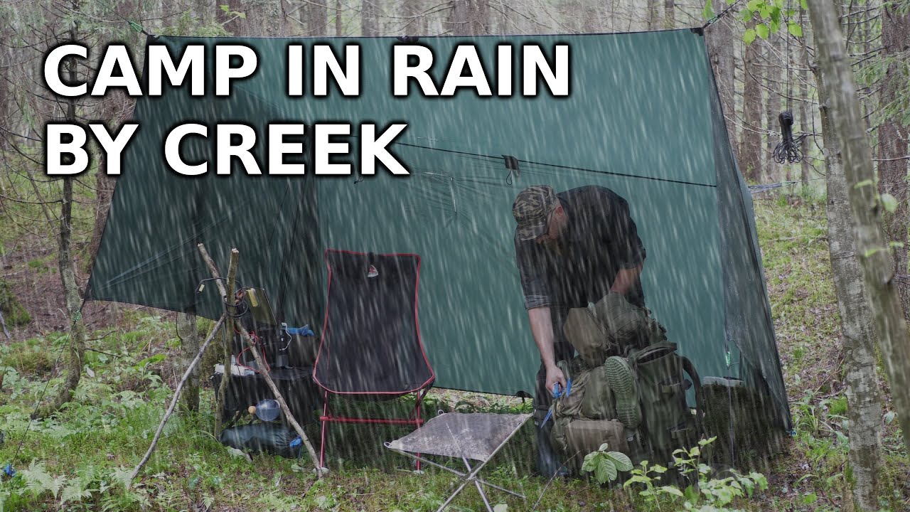 Rain every now and then when camping under tarp by creek, grill meat and relaxes
